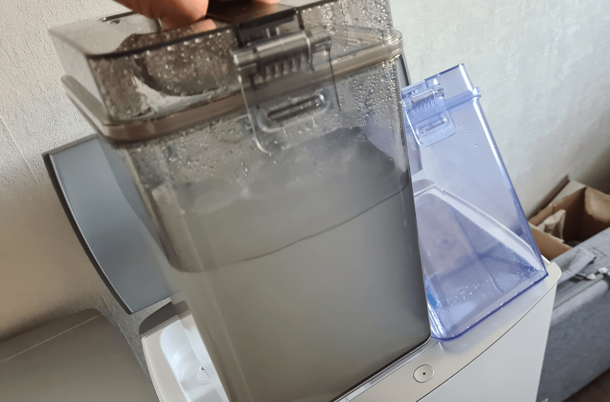 Der Schmutzwassertank der ECOVACS DEEBOT T20 OMNI Station wird in den Händen gehalten.